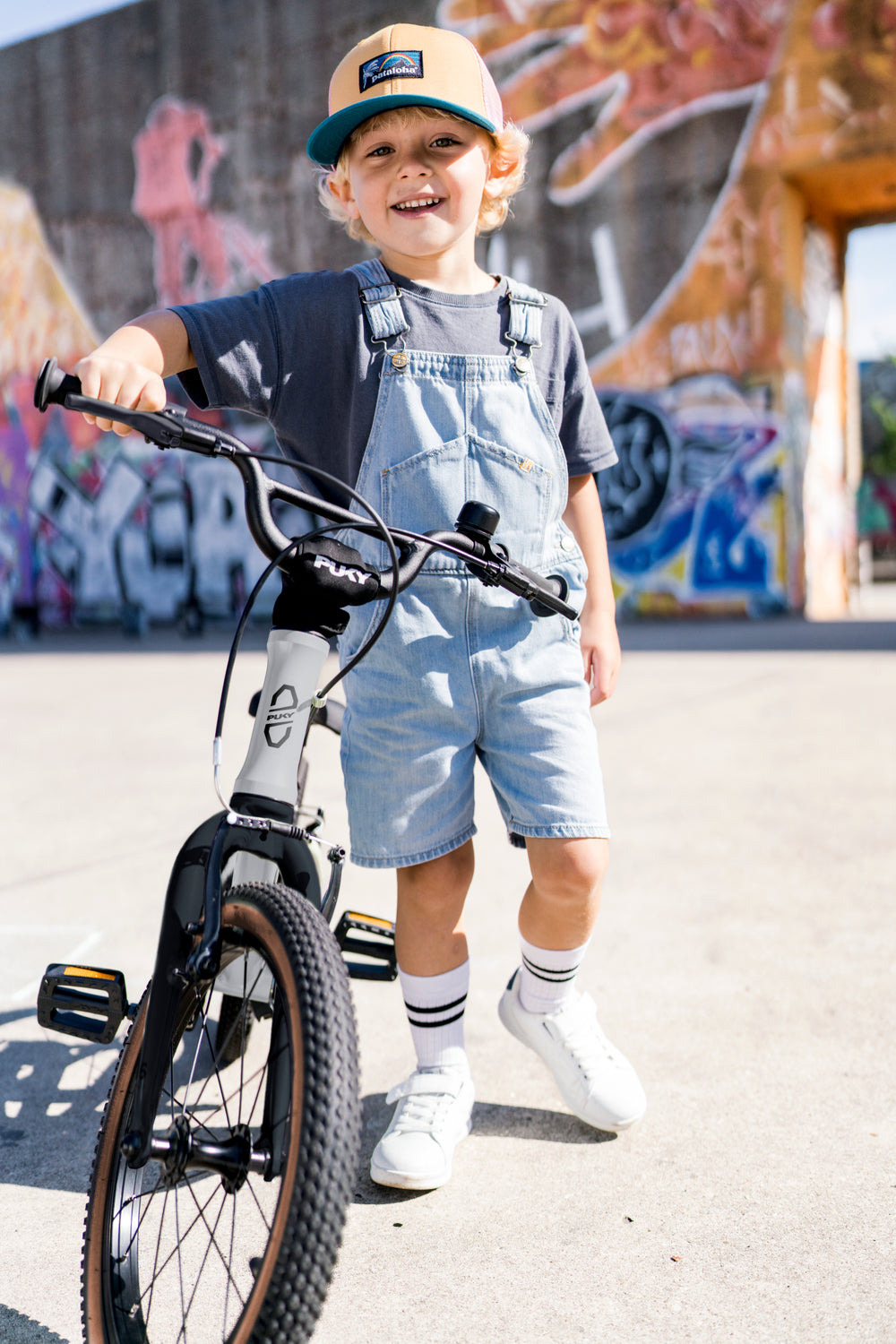 Kleiner Junge mit Kappe steht locker neben PUKY LS Pro 16